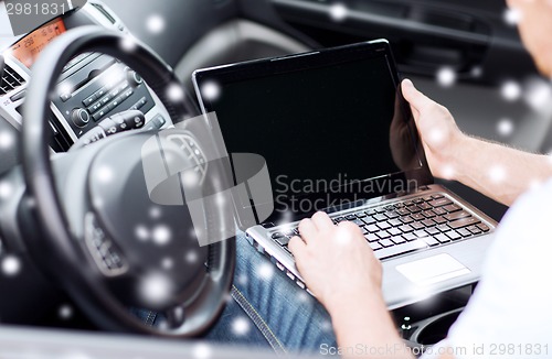 Image of close up of man using laptop in car