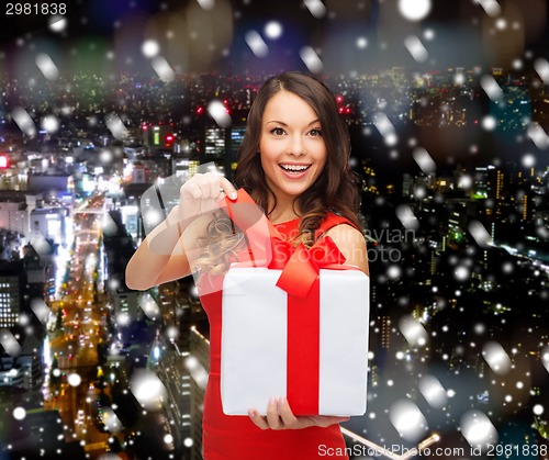 Image of smiling woman in red dress with gift boxes