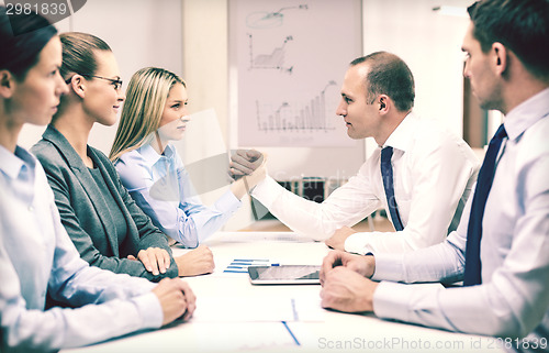 Image of businesswoman and businessman arm wrestling