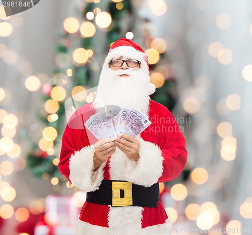 Image of man in costume of santa claus with euro money