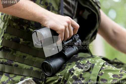 Image of close up of soldier or hunter with binocular