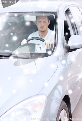 Image of man driving car and putting parking clock