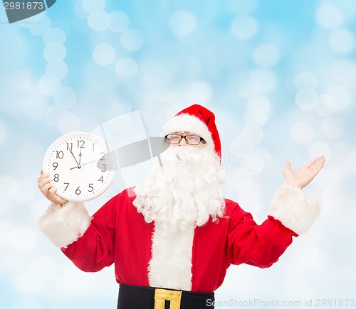 Image of man in costume of santa claus with clock