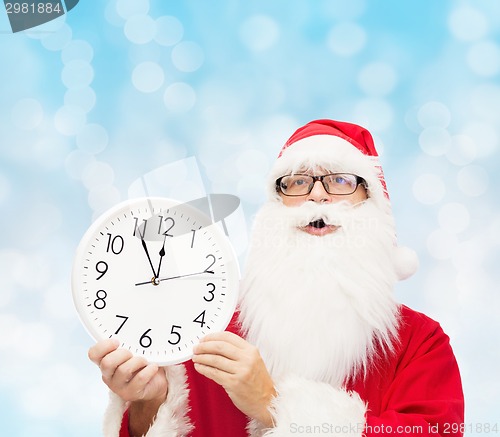 Image of man in costume of santa claus with clock