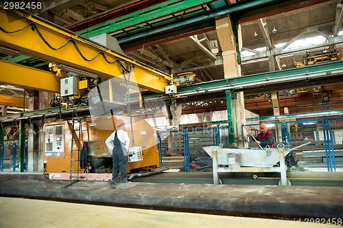 Image of Workers operate machine on filling of plates