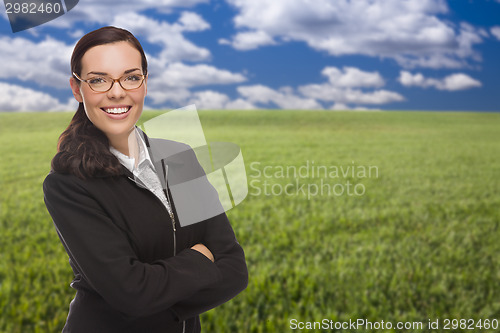 Image of Confident Woman in Grass Field Looking At Camera