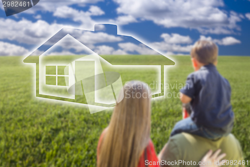 Image of Young Family in Grass Field with Ghosted House in Front