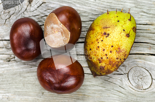 Image of Sweet chestnuts at wooden background