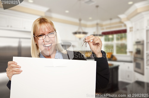 Image of Young Woman Holding Blank Sign and Keys Inside Kitchen