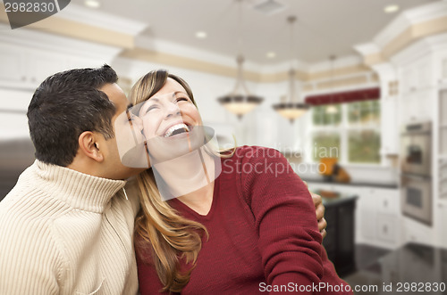 Image of Mixed Race Couple Kissing Inside Beautiful Custom Kitchen