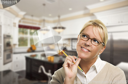 Image of Daydreaming Woman with Pencil Inside Beautiful Custom Kitchen