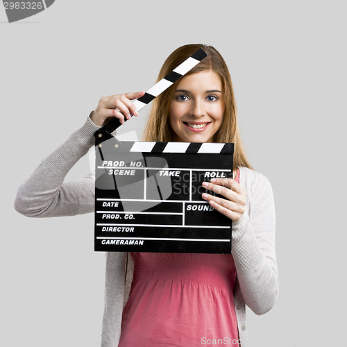 Image of Beautiful girl holding clapboard