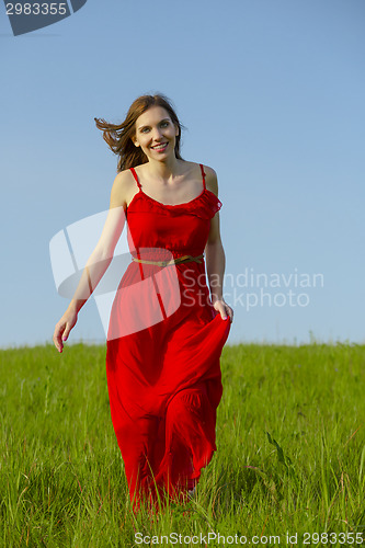 Image of Beautiful girl walking with a red dress