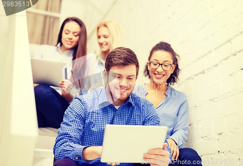 Image of team with tablet pc computer sitting on staircase