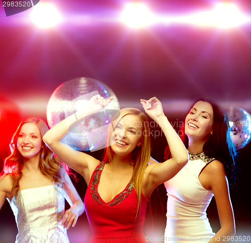 Image of three smiling women dancing in the club