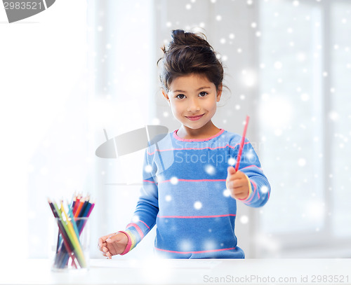 Image of smiling little girl with pencils drawing at home