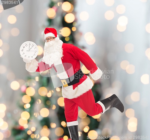 Image of man in costume of santa claus with clock