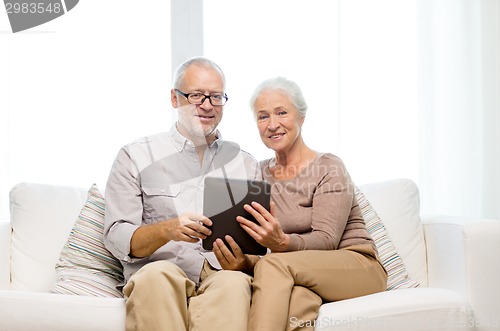 Image of happy senior couple with tablet pc at home