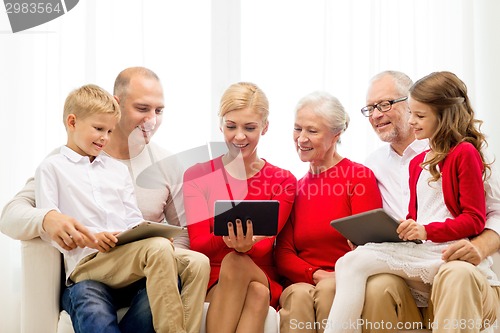 Image of smiling family with tablet pc computers at home