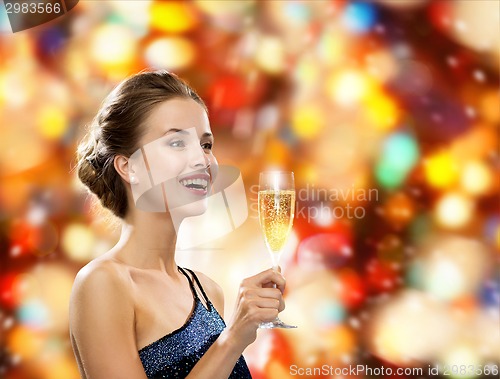 Image of smiling woman holding glass of sparkling wine