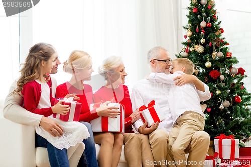 Image of smiling family with gifts at home