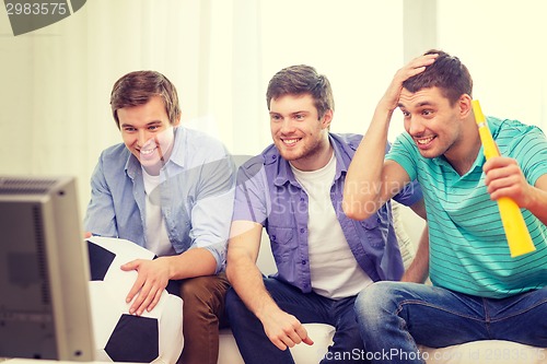 Image of happy male friends with football and vuvuzela