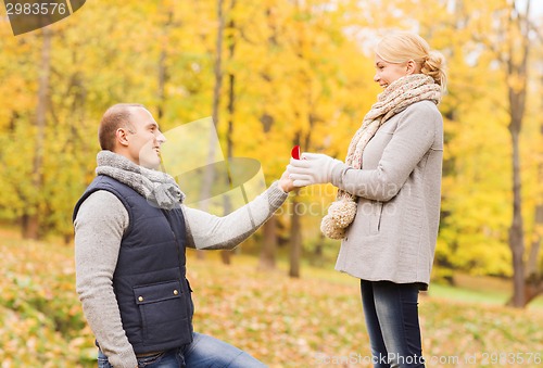 Image of smiling couple with engagement ring in gift box