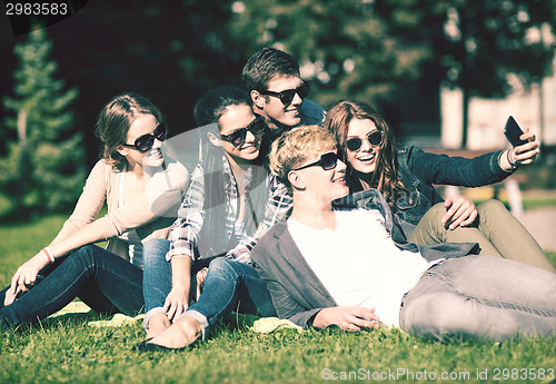 Image of teenagers taking photo outside with smartphone