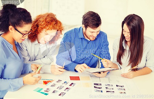 Image of team with color samples and blueprint at office