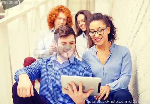 Image of team with tablet pc computer sitting on staircase