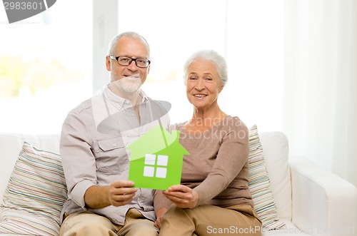 Image of happy senior couple hugging on sofa at home