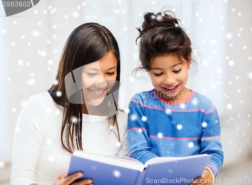 Image of mother and daughter with book indoors