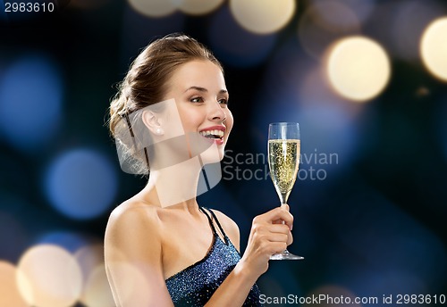 Image of smiling woman holding glass of sparkling wine