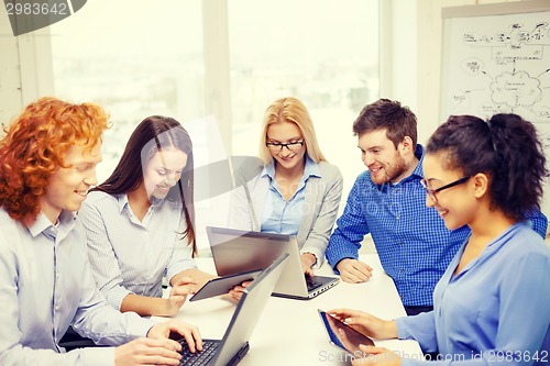 Image of smiling team with laptop and table pc computers