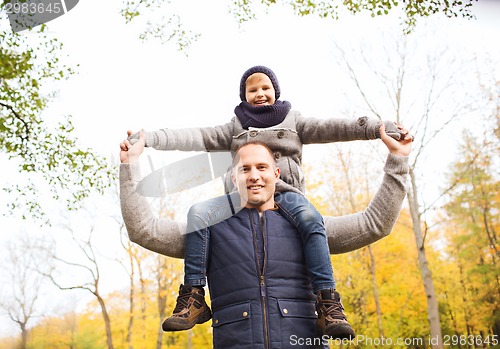 Image of happy family having fun in autumn park