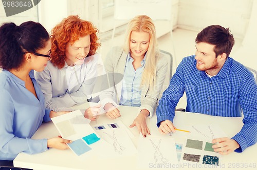 Image of smiling creative team looking at sketch