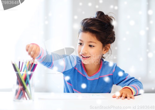 Image of smiling little girl with pencils drawing at home