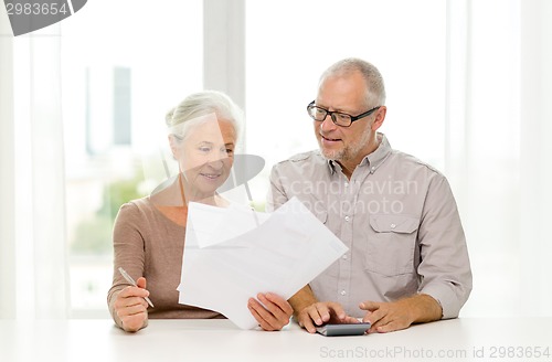 Image of senior couple with papers and calculator at home