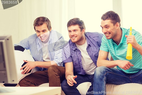 Image of happy male friends with football and vuvuzela