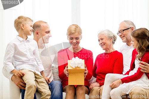 Image of smiling family with gift at home