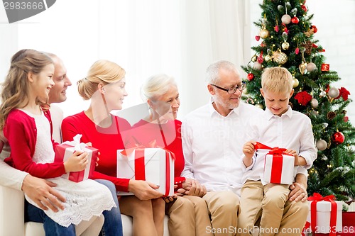 Image of smiling family with gifts at home