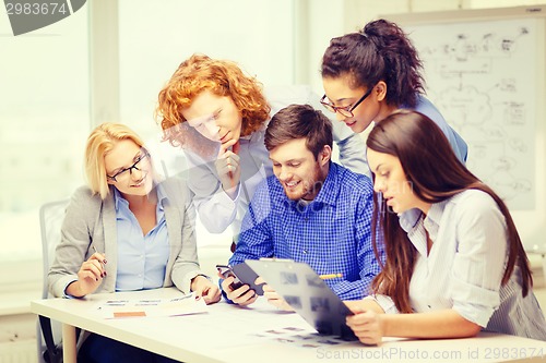 Image of creative team with papers and clipboard at office