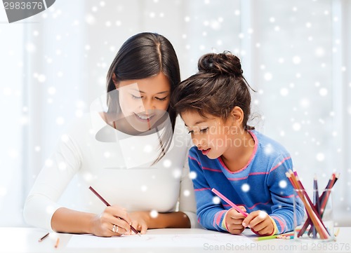 Image of mother and daughter with coloring pencils indoors