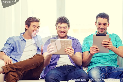 Image of smiling friends with tablet pc computers at home