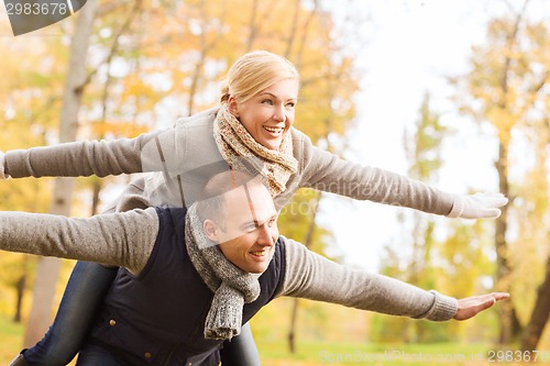 Image of smiling couple having fun in autumn park
