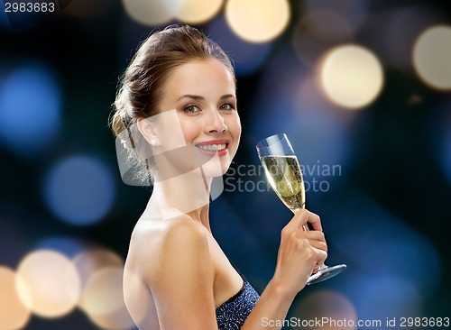 Image of smiling woman holding glass of sparkling wine