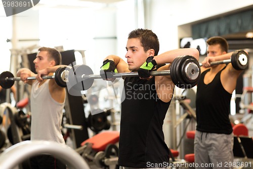 Image of group of men with barbells in gym