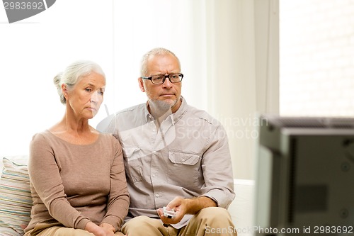 Image of senior couple watching tv at home