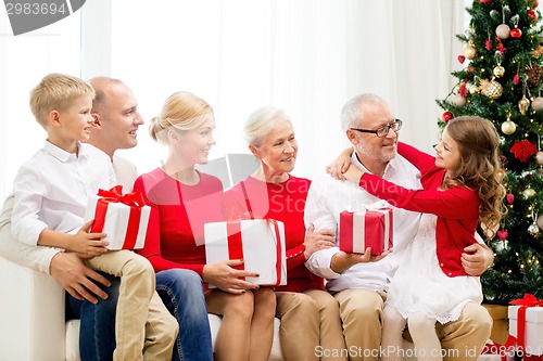 Image of smiling family with gifts at home