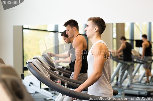 Image of group of men exercising on treadmill in gym